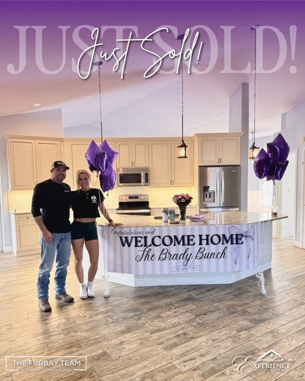 Clients in their new kitchen with a Welcome Home sign